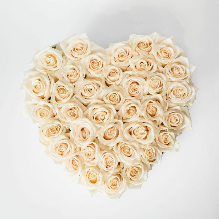 Composición de rosas blancas formando un corazón, diseño delicado.
