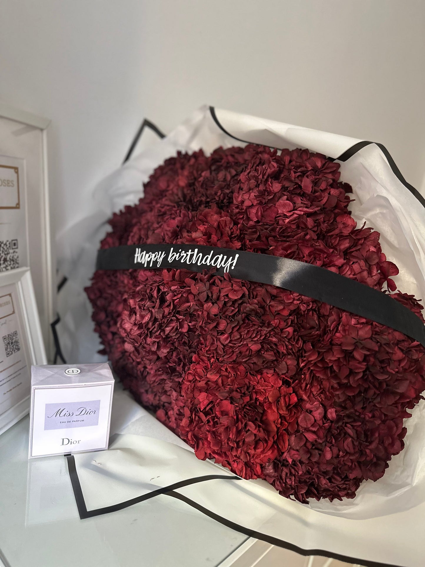 Corazón de hortensias eternas en tono burdeos para funerales, arreglo floral premium en forma de corazón con cinta  diseño exclusivo de The Prestige Funerarias Madrid.