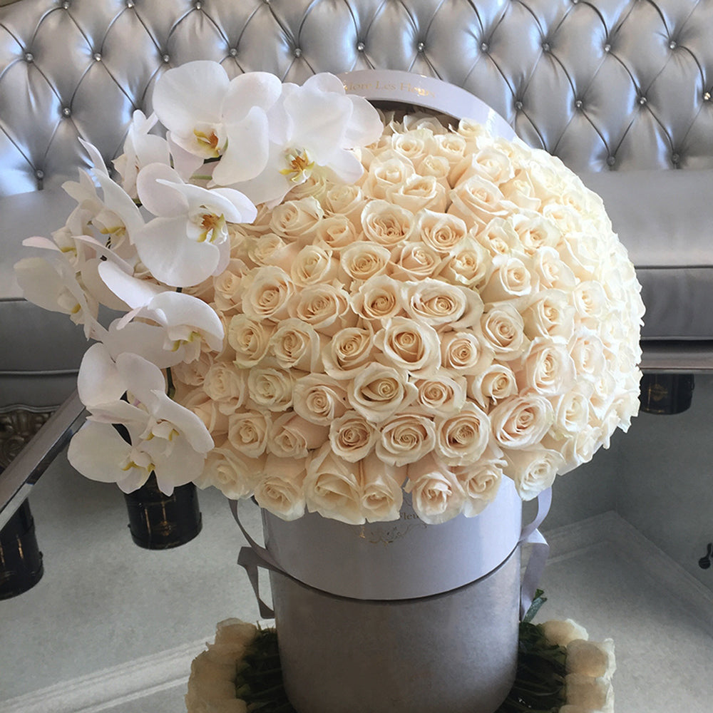 Arreglo funerario de rosas blancas en caja estilo cúpula con orquídeas blancas, diseño elegante para condolencias y homenajes en Madrid.