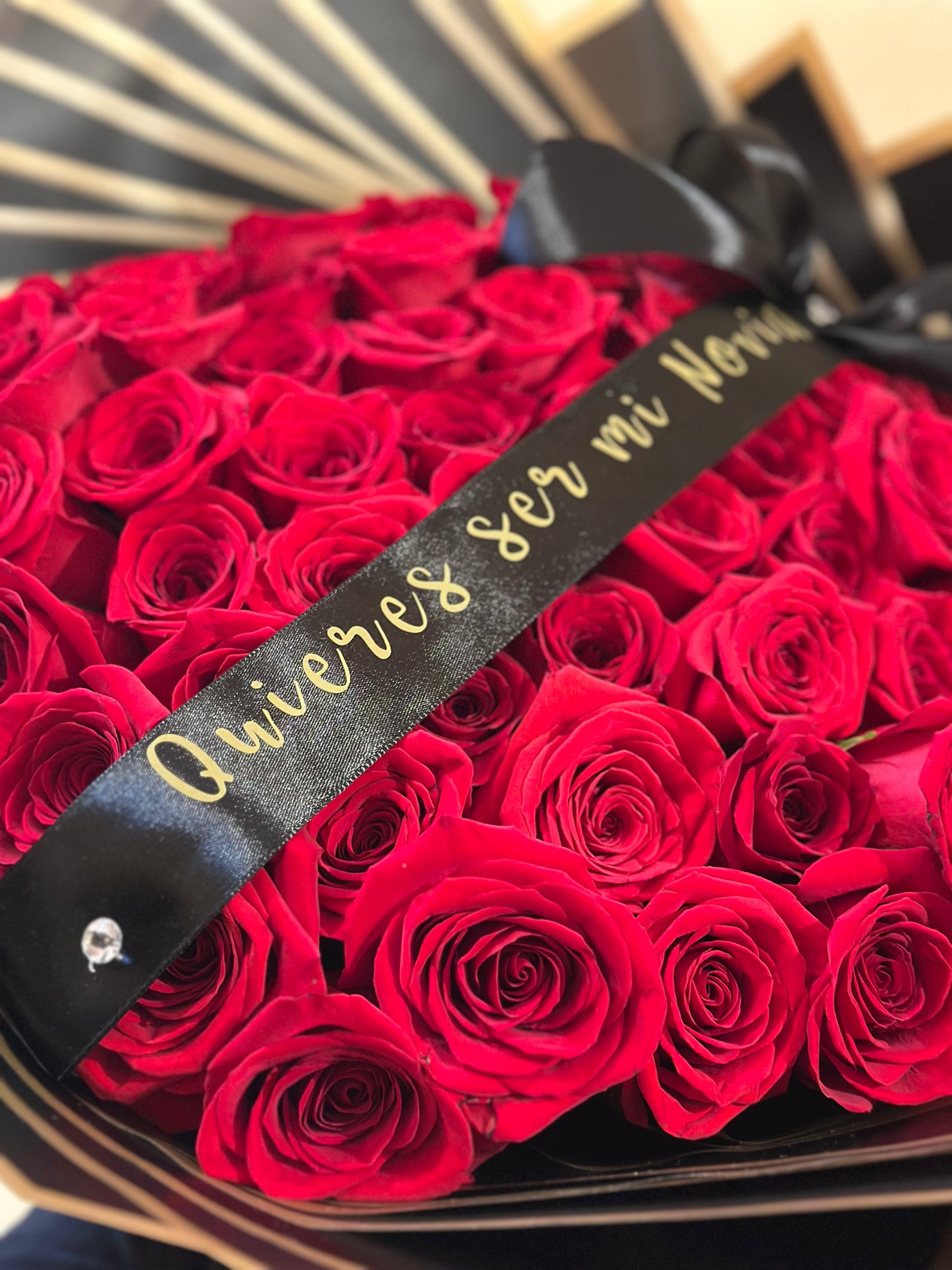 Detalle de cinta de condolencias en ramo de rosas frescas