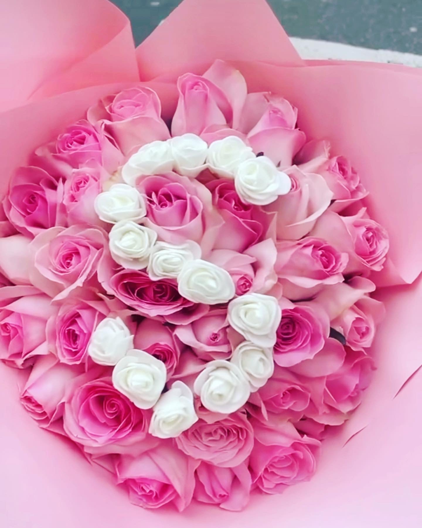 Corona floral circular con letra S formada por rosas frescas blancas y rojas – detalle para velatorios